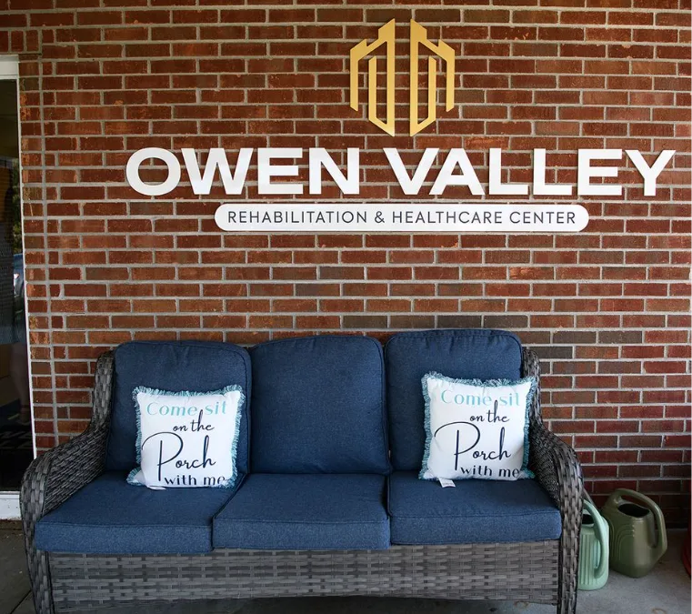 The Owen Valley sign on the brick wall above a porch sofa