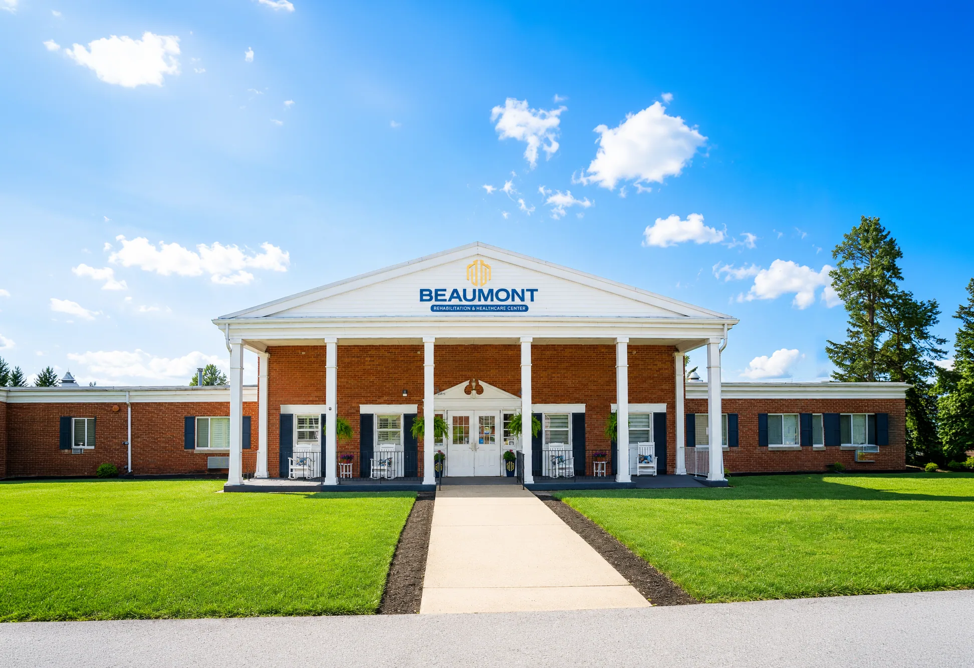 The Beaumont entrance, a white colonnade and brick frontage behind a lawn