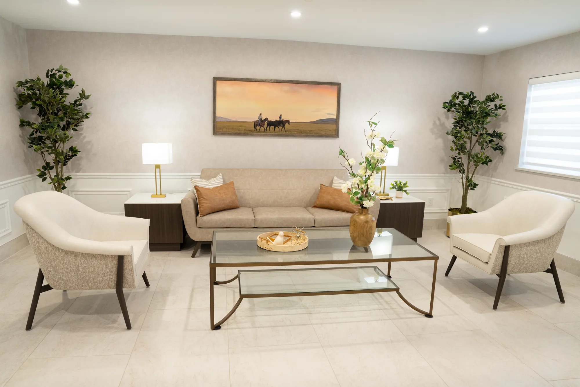 A lounge with armchairs, a low table and framed artwork