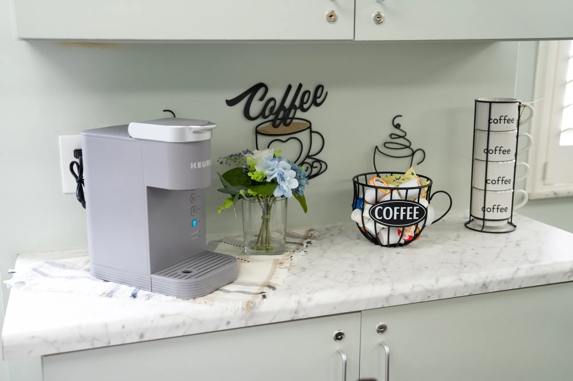 The coffee station, with a vase of flowers on the counter