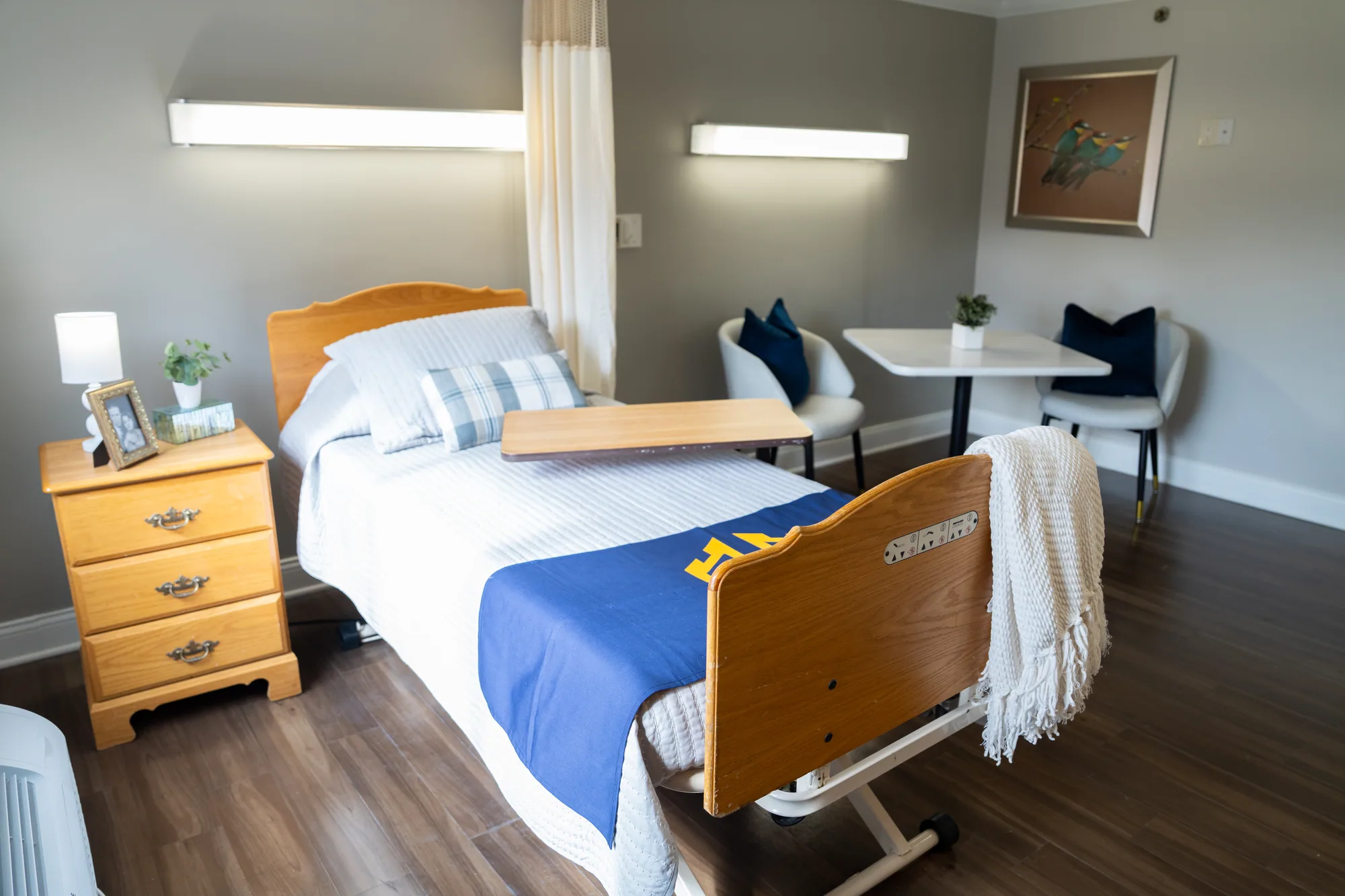 A resident room with a made bed beside the window