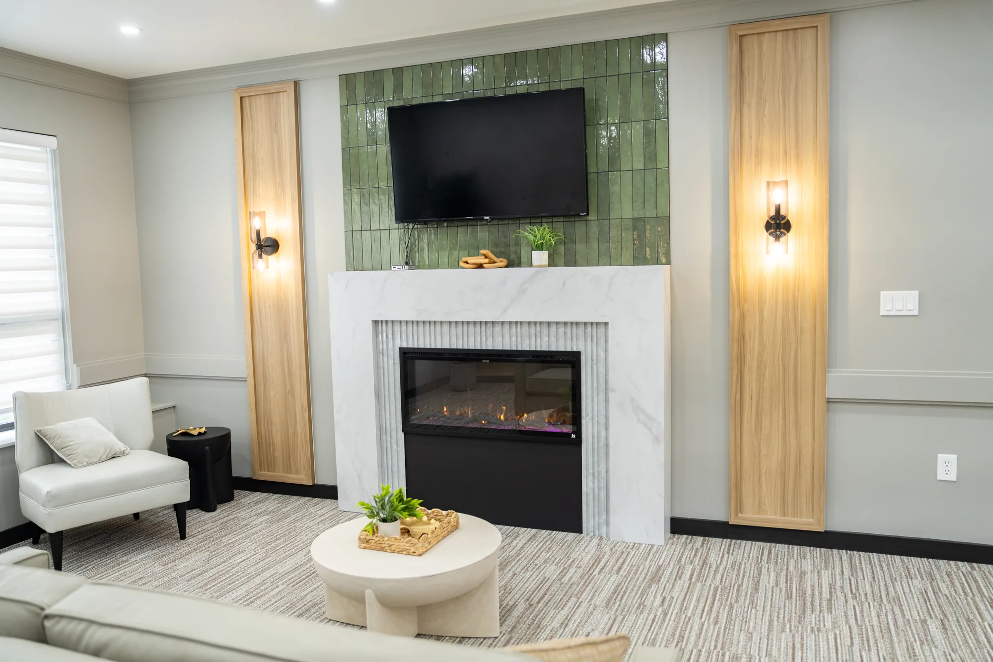 A sitting room with a television above the fireplace
