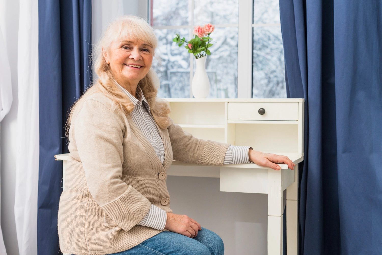 A resident beside a sunny window with fresh flowers